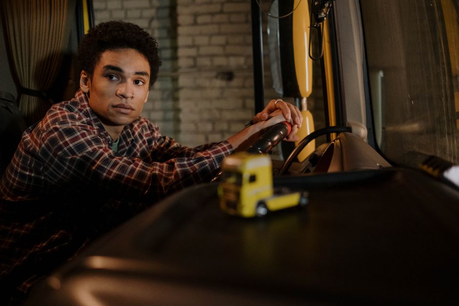 Een CE chauffeur die een vrachtwagen bestuurt tijdens een transportrit, met een focus op de vrachtvervoersector.